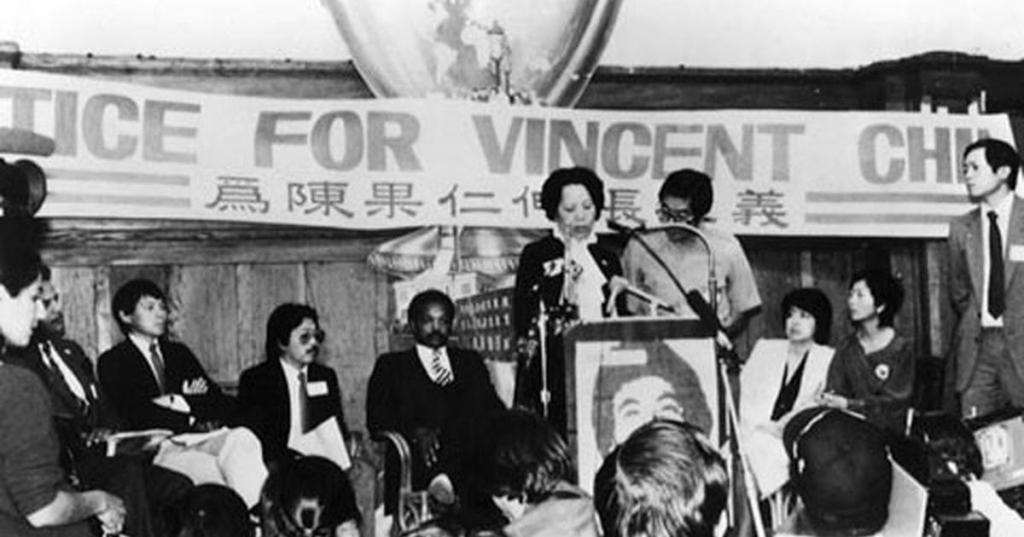 Lily Chin speaking in front of a banner that reads, "Justice for Vincent Chin." Courtesy of the collections of Helen Zia and the Vincent and Lily Chin Estate. 